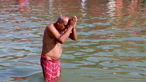 Hindu Devotee Offering Prayer While Standing in Sacred River During Holy Bath Stock Footage 338417894