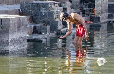 Hindu devotee old man bathing at pristine holy Shipra river at morning from.. 스톡 사진