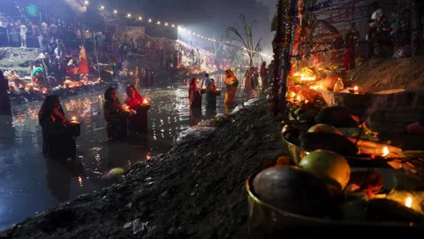Hindu devotee performing chhath puja prayers at riverbank in foggy morning Stock Footage 316801043