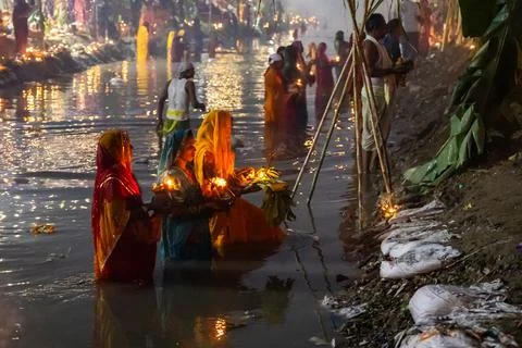 Hindu devotee performing chhath puja prayers at riverbank in foggy morning Stock-Fotos