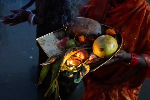 Hindu devotee performing holy rituals with daali offerings at chhath puja c.. Stock Photos