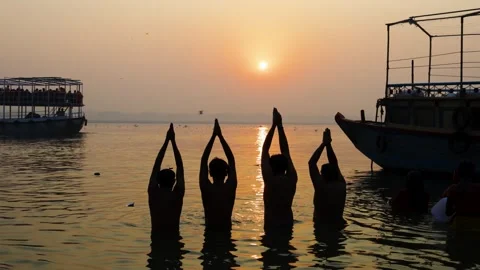 Hindu devotees performing sacred ganges river prayer during calm sunrise 库存影片 335435101