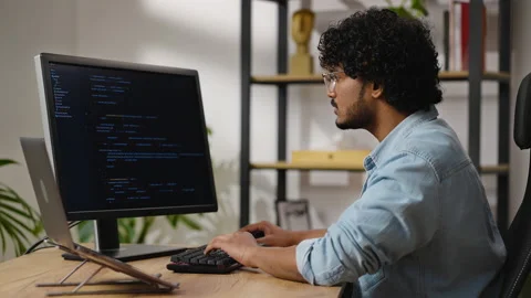Hindu man types source code sitting at desk in home office Stock Footage 239344147