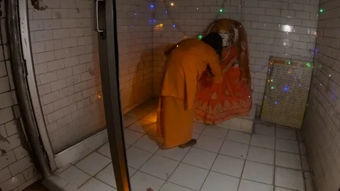Hindu monk performs night religious ritual aarti with fan light near statue of G Stock Footage 100333817
