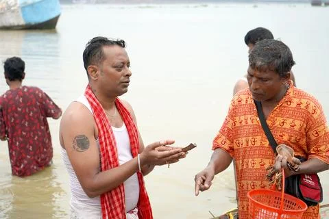 Hindu Priest and Devotee performing Tarpan Ritual by River in Kolkata During Mah Stock Photos