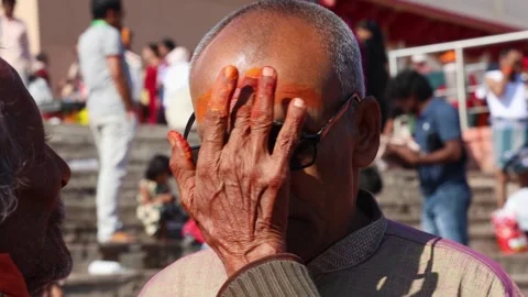 Hindu Priest Applying Sacred Tilak on Devotee Forehead During Religious Ritual Stock Footage 340814550