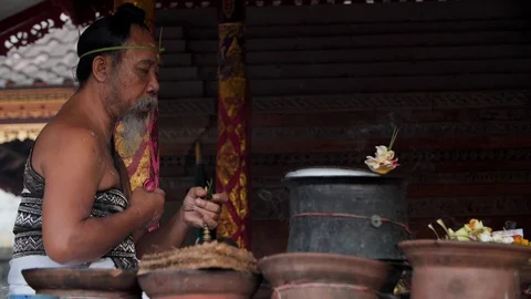 Hindu priest praying and preparing for Melukat Mebayuh Ceremonial in Bali Stock Footage 140297310