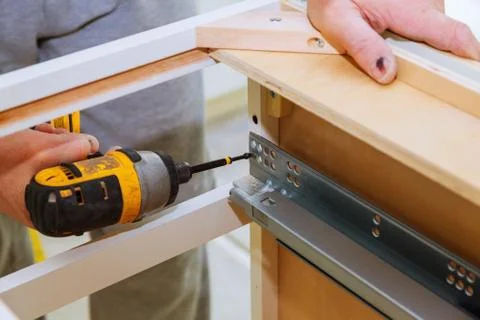 Hinge drawers assembly on kitchen cabinet door Stock Photos