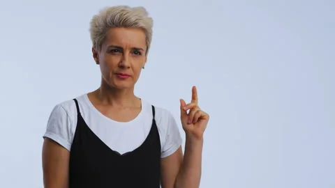 Hint idea gesture from a white haired mid age woman in black dress isolated on Stock Footage 143593913