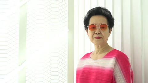 Hip cool Asian senior elder woman smile to camera in red pink hip fashion Stock Footage 145887707