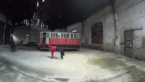 Hip hop dance, Back flip Man Dancing in an old train factory Stock Footage 104463014