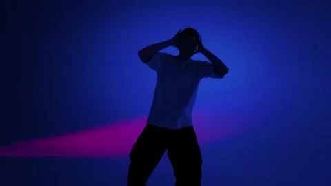 Hip hop dancer extending an arm in blue and purple studio light Stock Footage 345601311