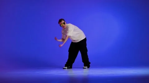 Hip hop dancer performing energetic move in blue studio Stock Footage 345601932