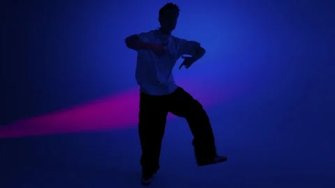Hip Hop Dancer Performs Sharp Freestyle Moves in Blue Studio Stock Footage 345601333