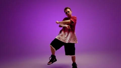 Hip hop dancer posing with sharp movement in a purple studio Stock Footage 345602450