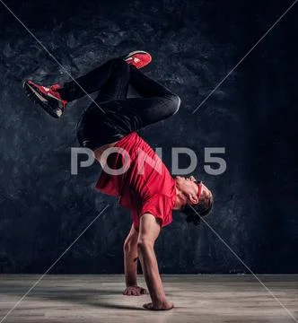 Hip-hop style dancer performs breakdance acrobatic elements. Stock Photos