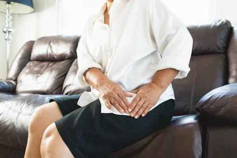 Hip pain of senior woman at home, healthcare problem of senior concept Stock Photos