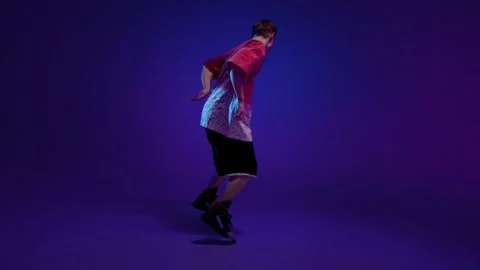 HipHop dancer performing energetic freestyle move in purple studio Stock Footage 345601921