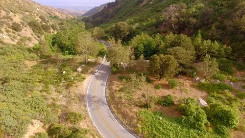 Hippie Mini Van Driving on the Road Through Hills Nature Aerial Drone View 動画素材 128485618