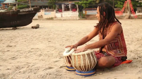 Hippy play on the drum and sit on the beach Stock Footage 26322087
