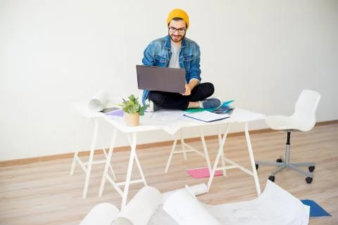 Hipster architect working with construction plans Stock Photos