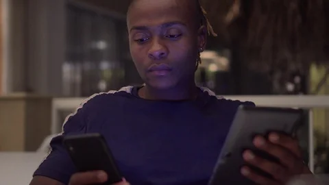 Hipster Black Man Addicted To Social Media On Devices Mobile Phone And Tablet Stock Footage