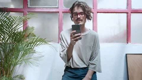 Hipster is chatting or scrolling in mobile app or social network in smartphone Stock Footage 98896667
