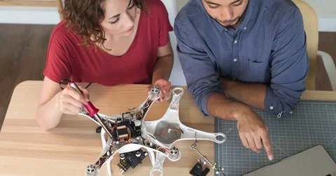 Hipster Engineers Building A Robot In A Startup Tracking Shot Man and Woman Stockbeeldmateriaal 82672417