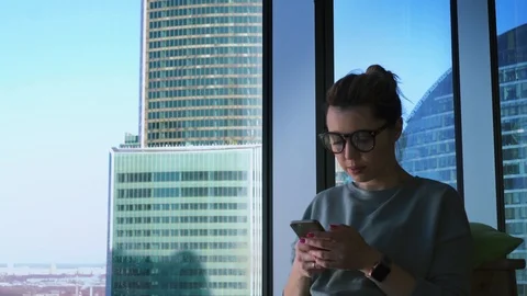 Hipster female in glasses is using apps on her mobile phone and taking photos of Stock Footage 88636820