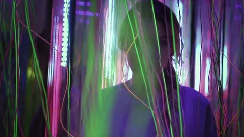 Hipster female is looking to the camera and touching neon lights. Young woman is Stock Footage 87183911