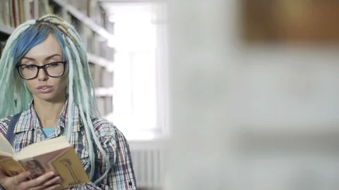 Hipster female student studiyng hard in library Stock Footage 106943365