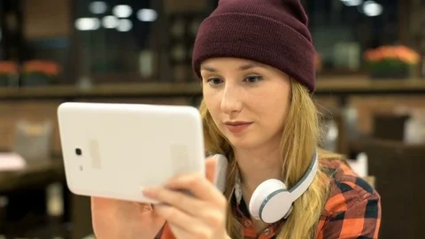Hipster girl browsing internet on tablet and smiling to the camera, steadycam sh Stock-Footage 71551476