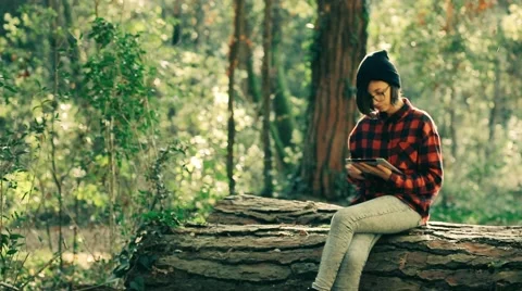 Hipster girl using digital tablet in the forest. Handheld shot Stock Footage 47315278
