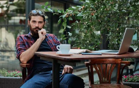 Hipster guy in a cafe thinking Stock Photos
