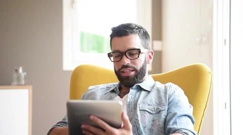 Hipster guy relaxed at home using digital tablet Stock Footage 64761481