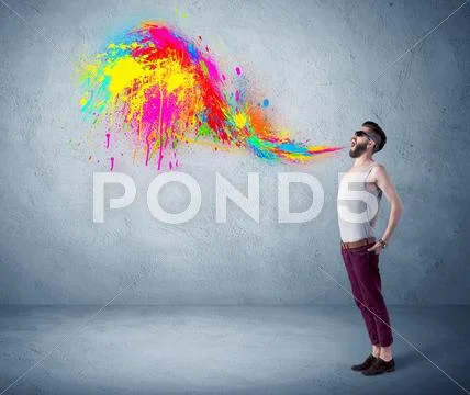 Hipster guy shouting colorful paint on wall Stock Photos