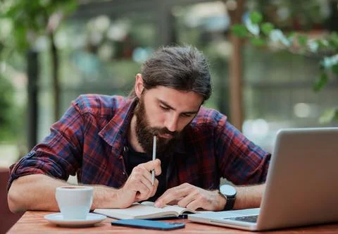 Hipster guy taking notes in a notebook. Foto stock