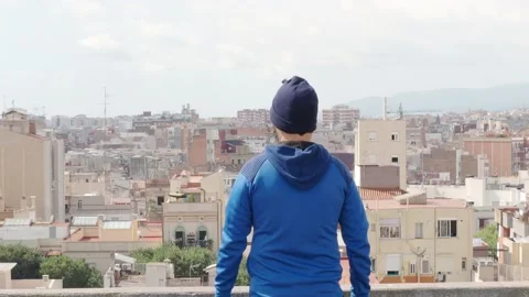 Hipster man from behind with hat observes in a city from a rooftop Stock Footage 139751673