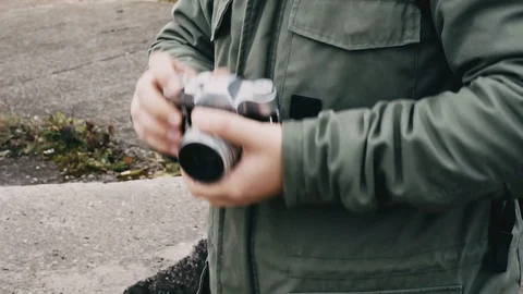 Hipster man cocking the shutter on vintage film dslr camera. Stock Footage 97792149