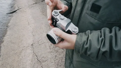 Hipster man cocking the shutter on vintage film dslr camera. Stock Footage 97792156
