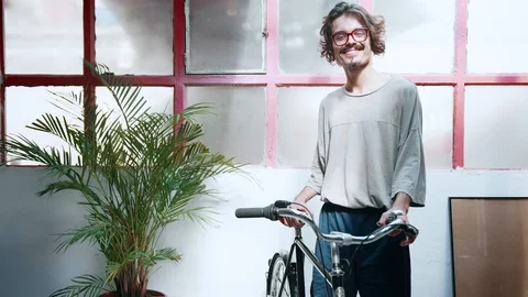 Hipster man looking to camera and smiling and keeping old school retro bicycle Stock Footage 98896052