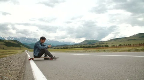 Hipster man model with smartphone resting at car trip with winter fashion Stock Footage 65402828