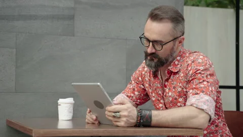 Hipster man playing tablet, he is thinking about his work. Stock Footage 146265761