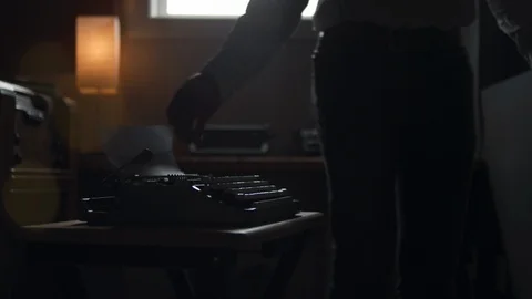 Hipster man sits down to type at his old vintage typewriter Stock Footage 97858646