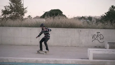 Hipster man skating around empty fountain in pedestrian street in the city Stock Footage 209474077