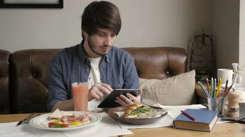 Hipster Man Using Digital Tablet  Eating Healthy Breakfast Stock Footage 61929587