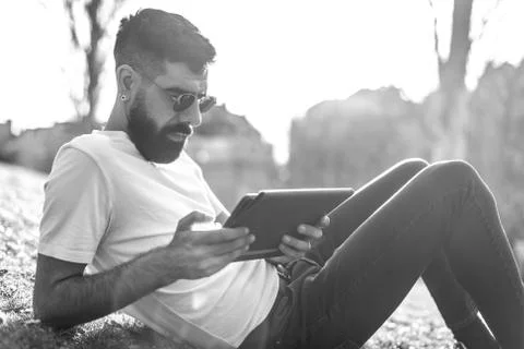 Hipster Man Using a digital Tablet in a Park. Stock Photos
