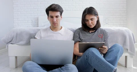 Hipster man using laptop and working remotely online. Woman is shopping online Stock Footage 127703889