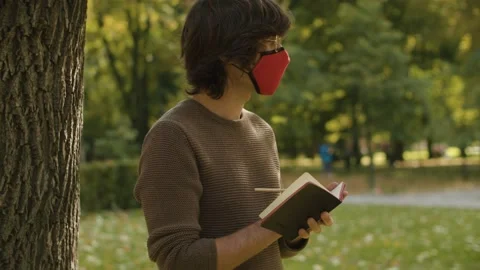 Hipster in mask writing in a diary Video stock 142459212
