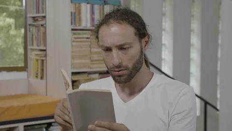 Hipster student man having fun reading an interesting book expressing amazeme Stock Footage 96125087